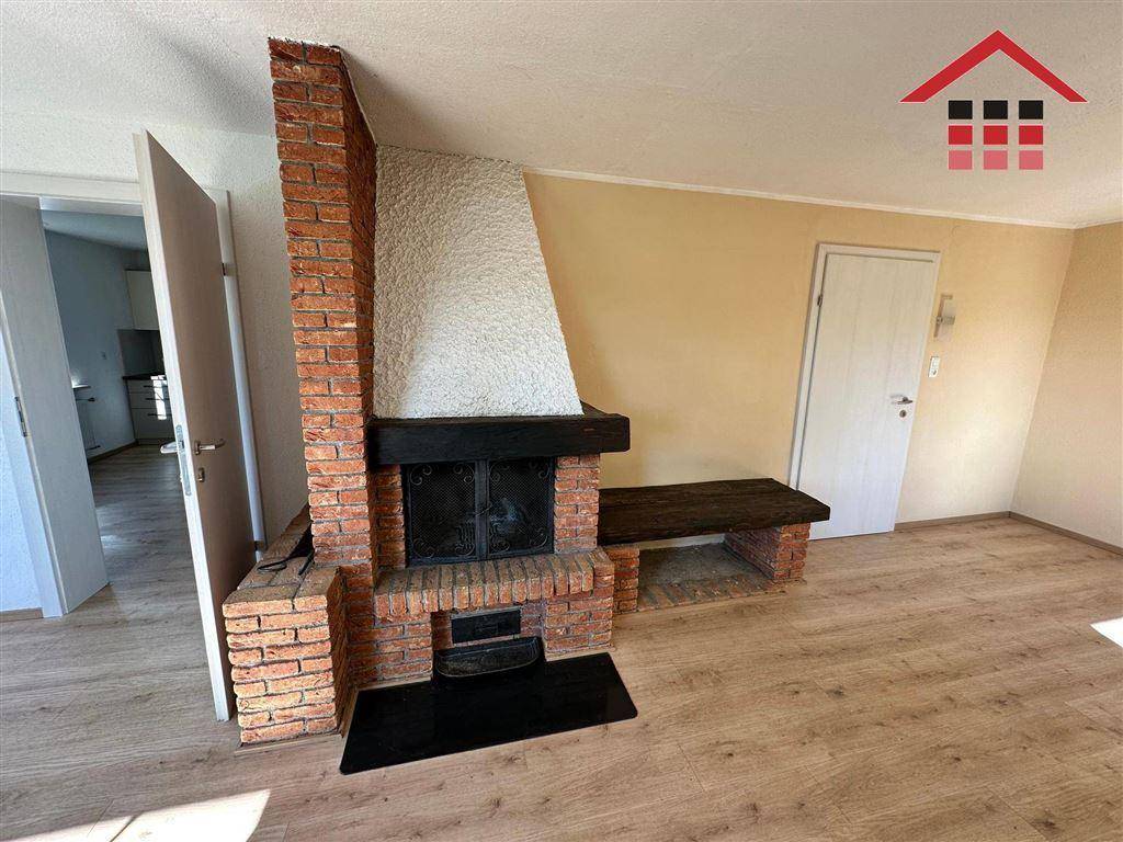 Gemütlicher Kamin aus Ziegelstein mit Sitzbank im Wohnbereich, ideal für kalte Abende.