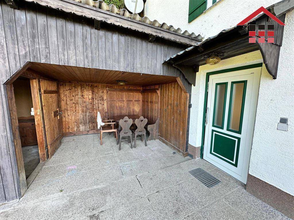 Überdachter Außenbereich mit Holztäfelung und Sitzgelegenheiten, ideal für gesellige Stunden.