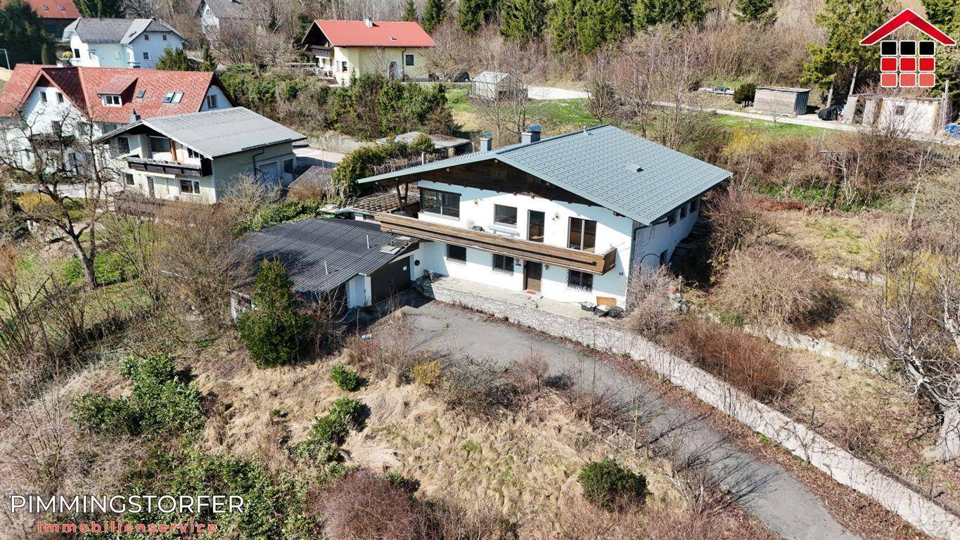 Luftaufnahme eines Hauses mit großem Grundstück und umliegender Natur in ländlicher Umgebung.