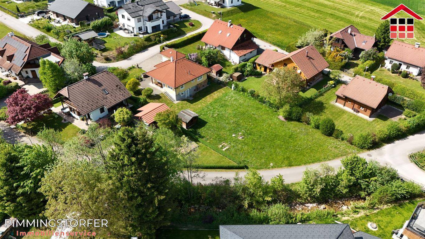 Luftaufnahme einer ländlichen Wohnsiedlung mit Einfamilienhäusern und viel Grünfläche.