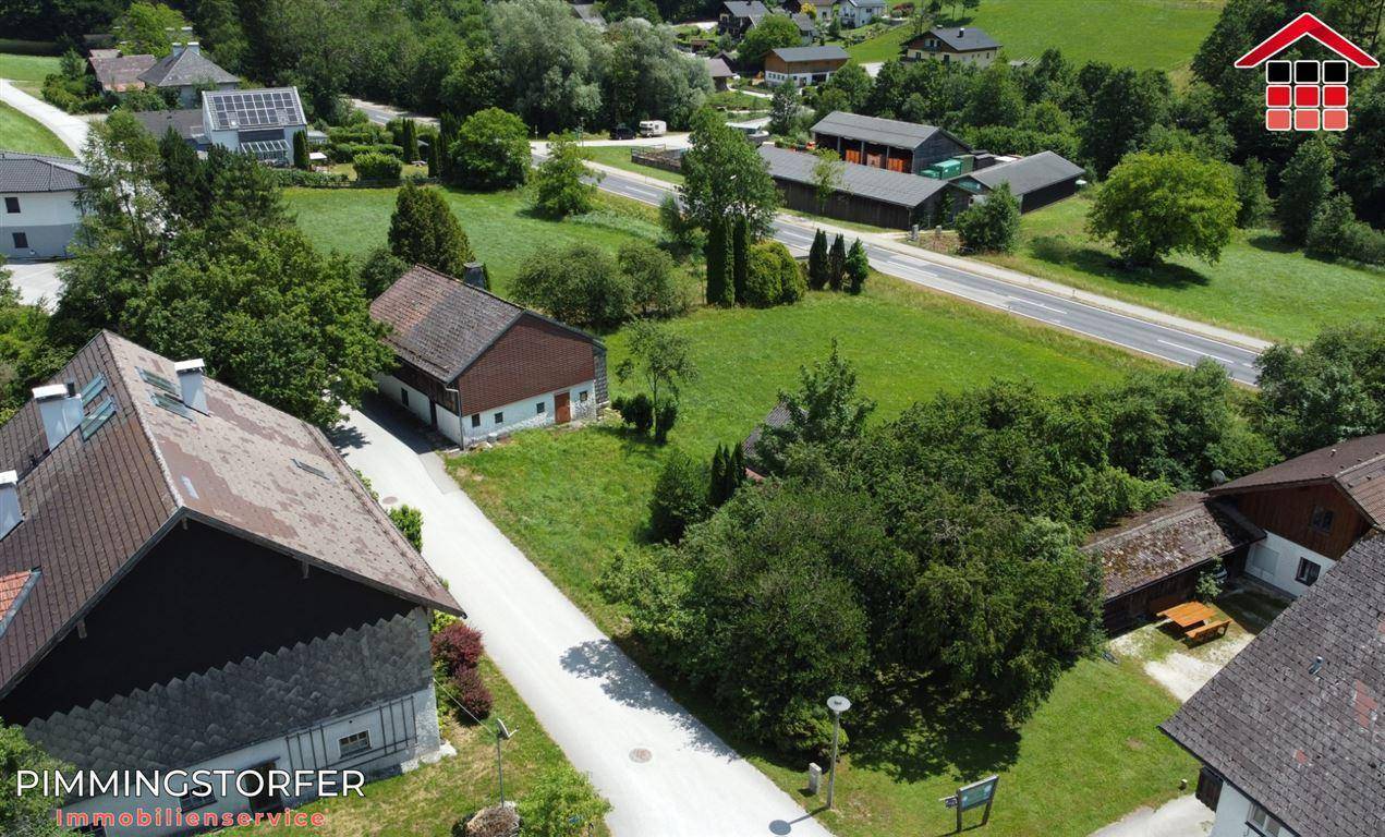 Luftaufnahme eines Grundstücks mit einem Haus, Wegen und angrenzenden Feldern in ländlicher Gegend.