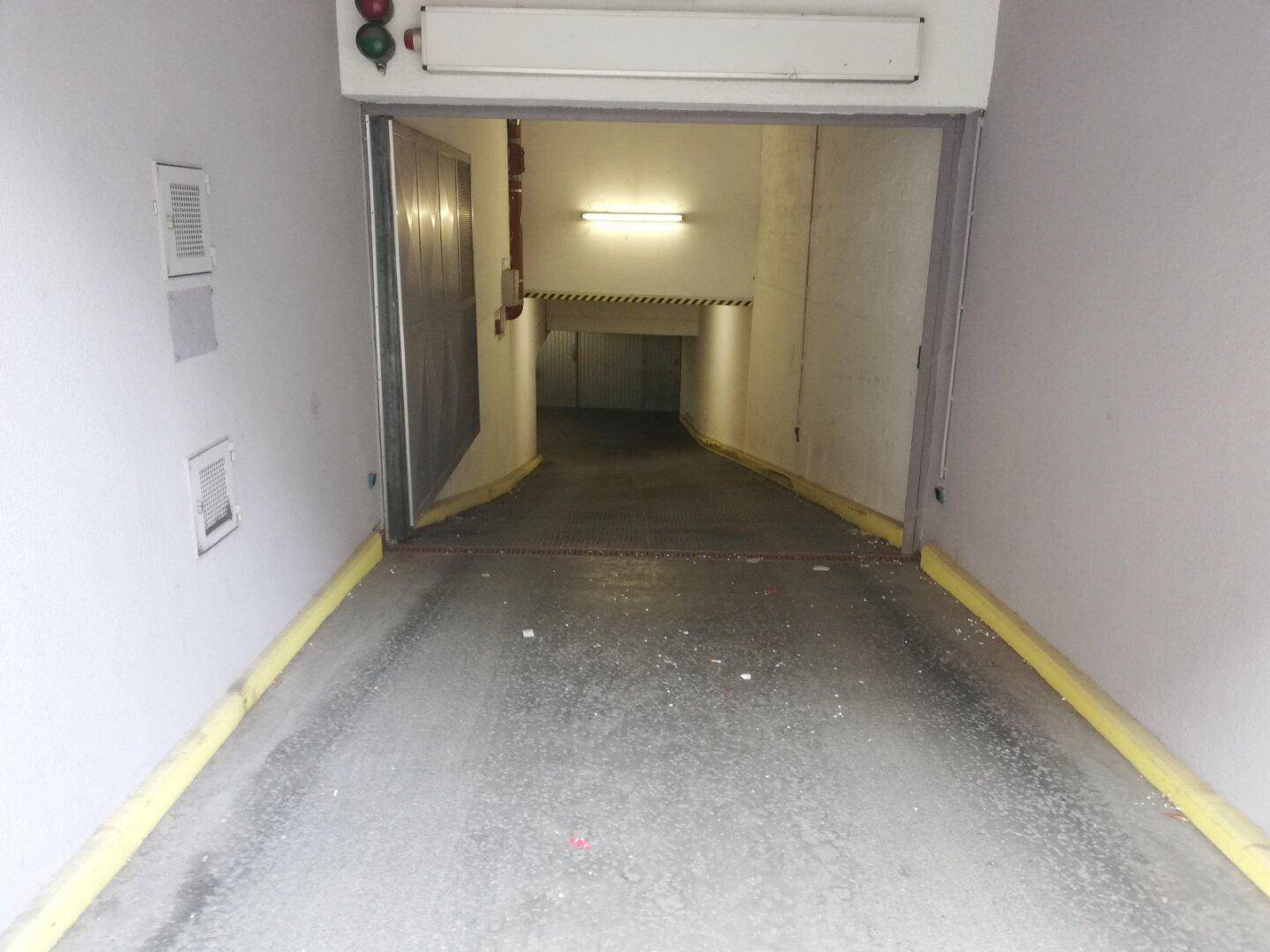 Einfahrt zur Tiefgarage mit gelben Markierungen und Ampelsystem.