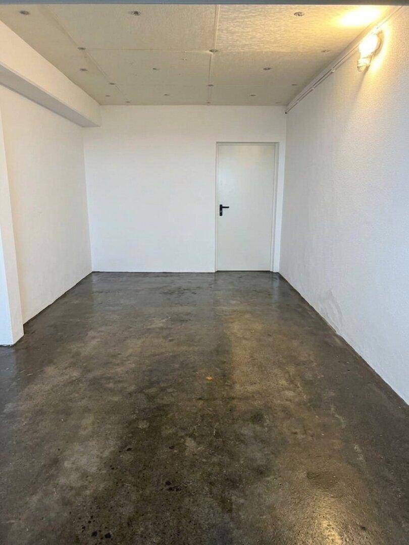 Geräumiger Kellerraum mit robustem Betonboden und weiß gestrichenen Wänden, vielseitig nutzbar.