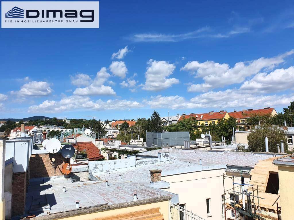 Blick über die Dächer der Stadt mit Satellitenschüsseln und einem sonnigen Himmel.