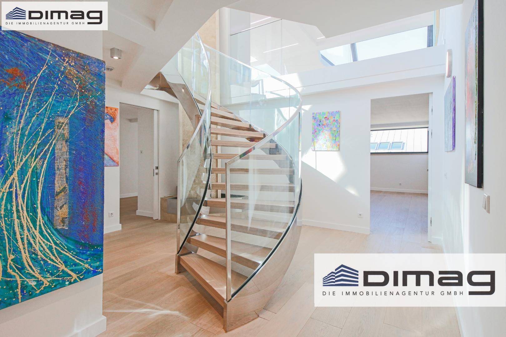 Heller Eingangsbereich mit eleganter Wendeltreppe und Kunstwerken, die den modernen Stil betonen.