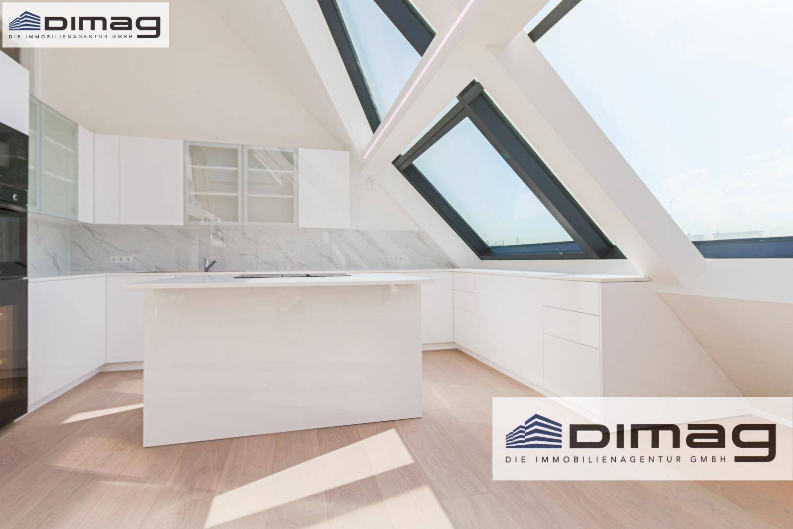 Elegante weiße Küche mit Kochinsel und Marmor-Arbeitsplatten, ergänzt durch schräge Dachfenster.