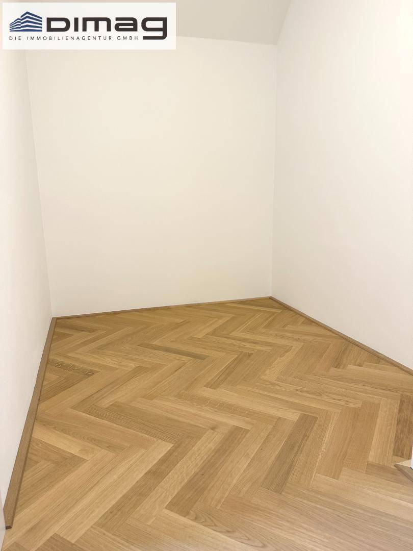 Kleiner Raum mit neuem Fischgrätparkett und weißen Wänden, ideal als Abstellraum oder begehbarer Kleiderschrank.