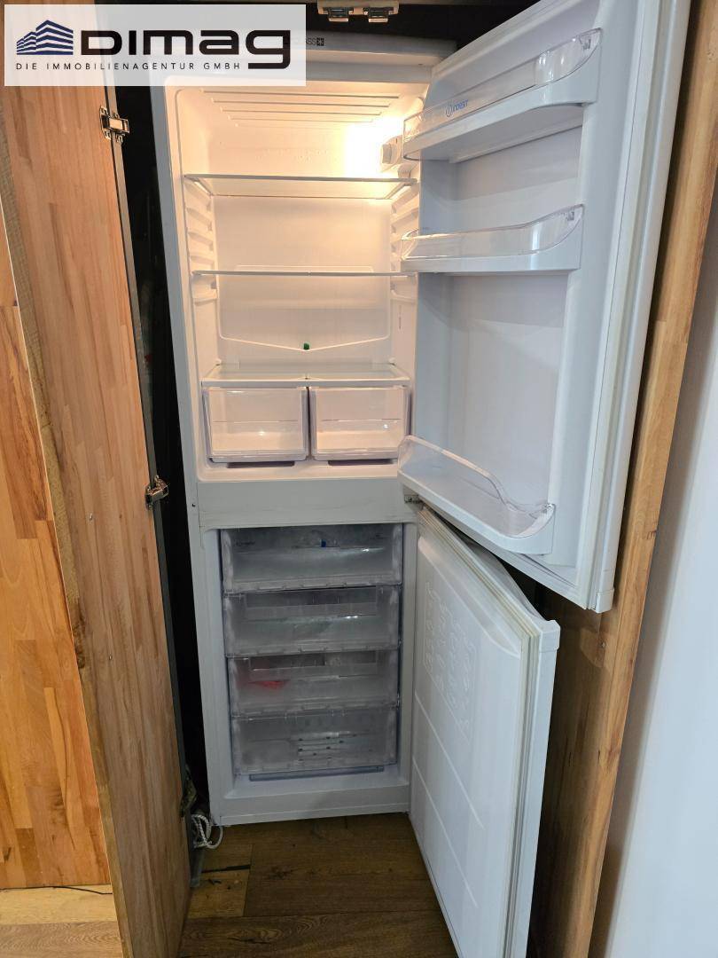 Heller Kühlschrank mit Gefrierfach, eingebettet in eine Holzwand.