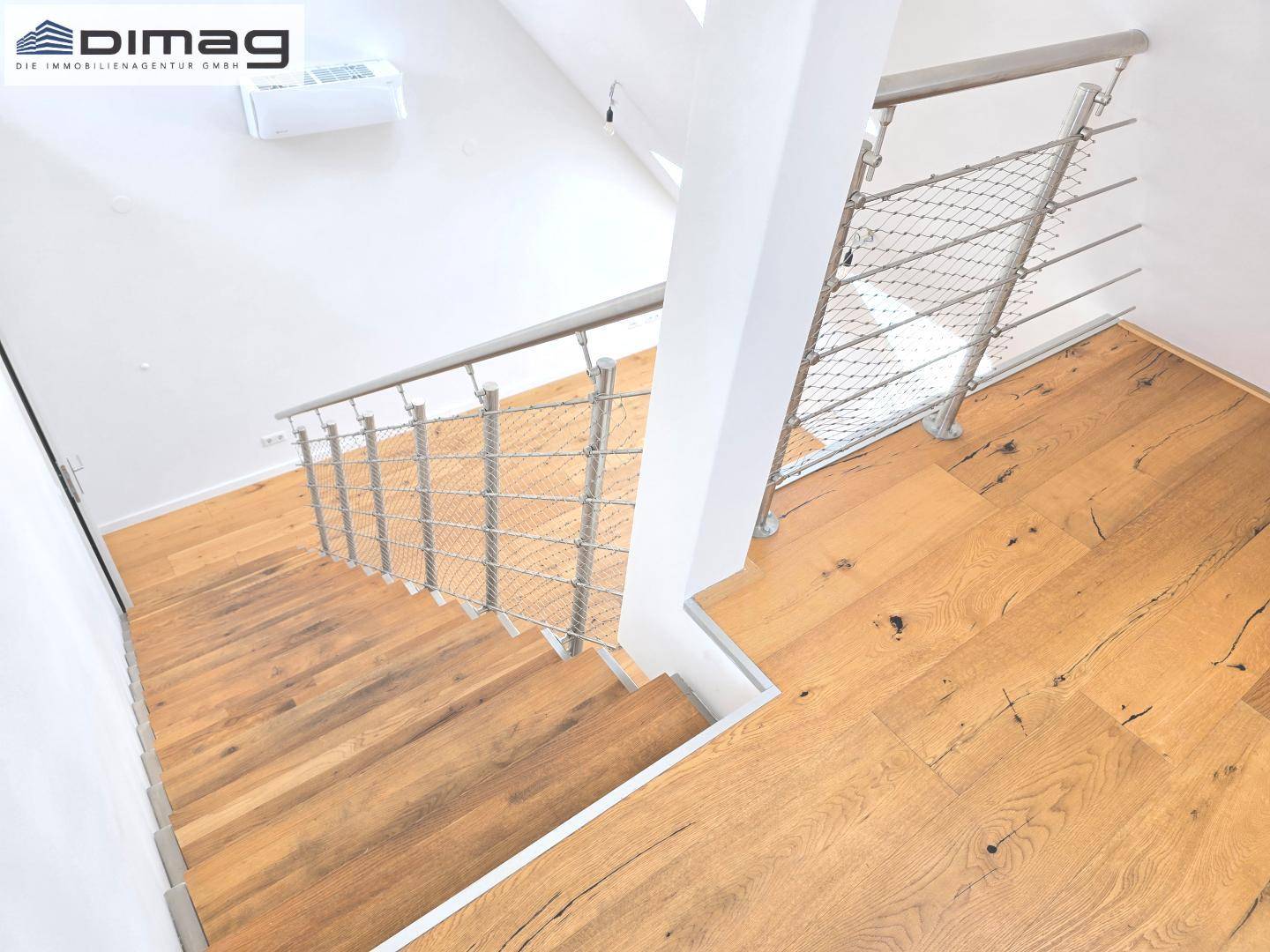 Moderne Holztreppe mit Edelstahlgeländer, verbindet die verschiedenen Wohnebenen.