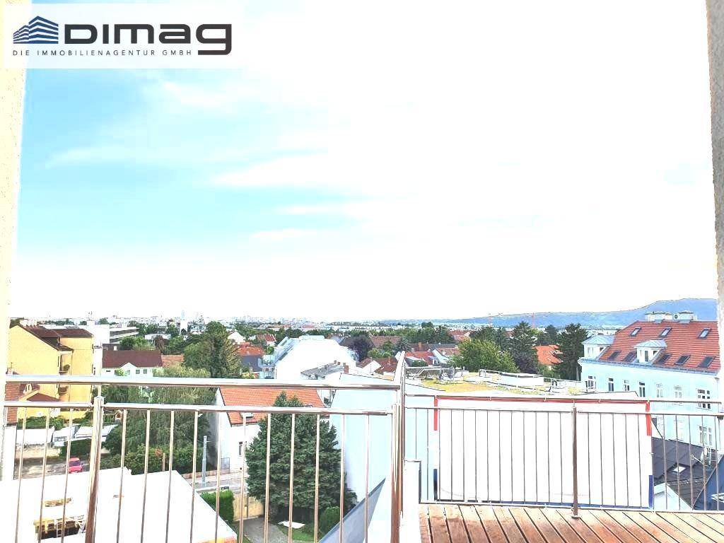Weitläufiger Ausblick von der Dachterrasse auf die Stadt und die grüne Umgebung unter blauem Himmel.