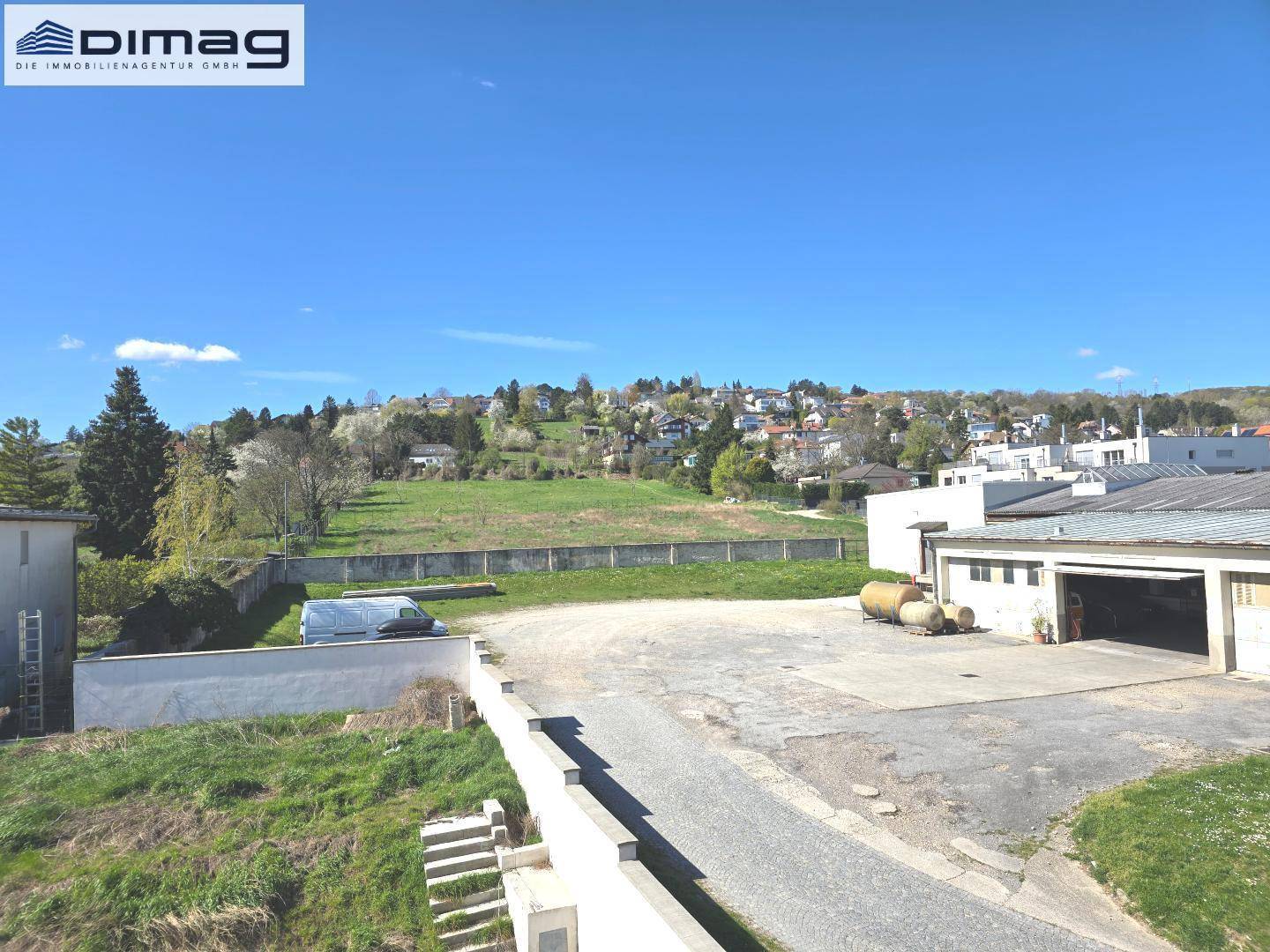 Panoramablick über das Grundstück mit weitem Blick auf die hügelige Landschaft und den blauen Himmel.