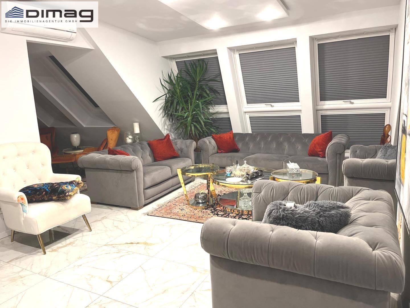 Elegantes Wohnzimmer mit bequemen Sofas, Dachschrägen und stilvoller Dekoration.