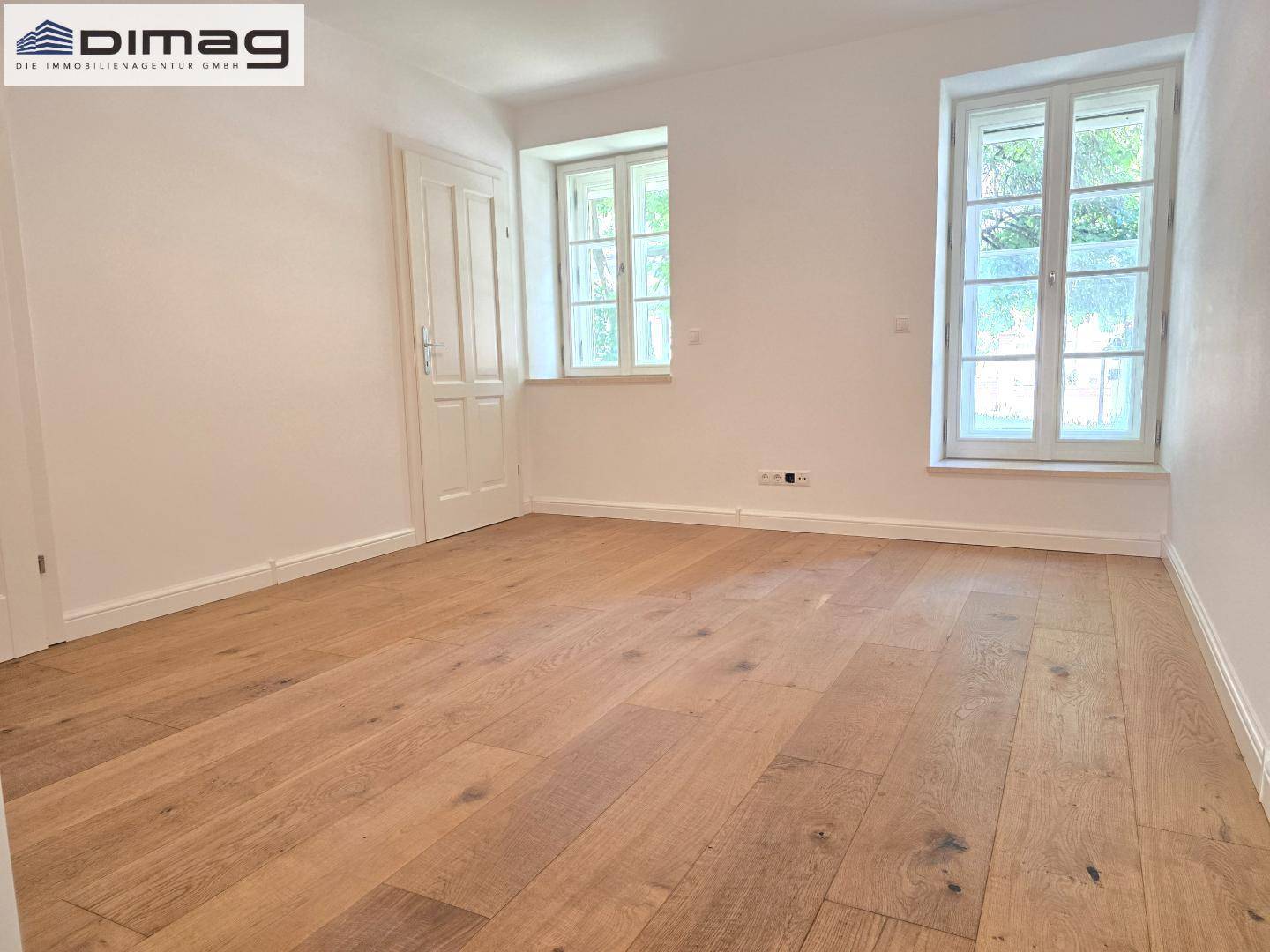 Helles Zimmer mit Holzboden und zwei Fenstern, ideal als Schlaf- oder Arbeitszimmer nutzbar.