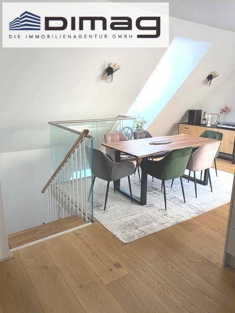 Heller Essbereich mit modernem Holztisch, stilvollen Stühlen und einer eleganten Glasbrüstung.