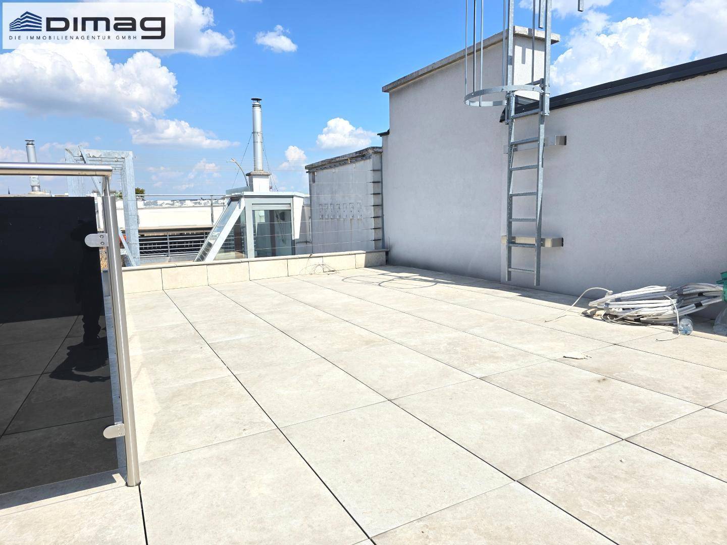 Geräumige Dachterrasse mit Leiterzugang und weitem Blick über die umliegende Bebauung.