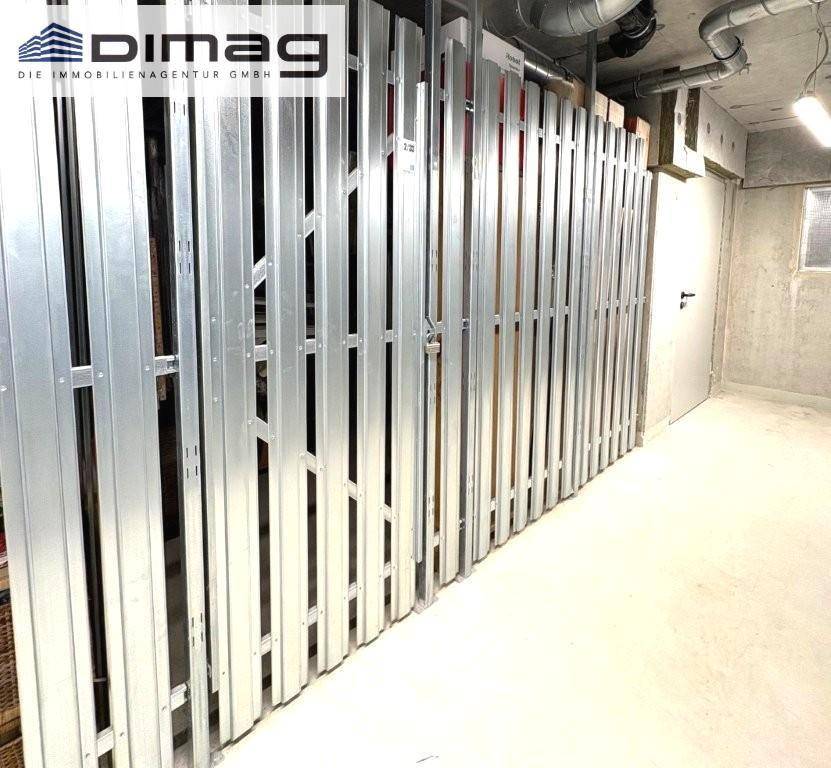 Abstellraum im Keller mit Metallabtrennungen und Betonboden.