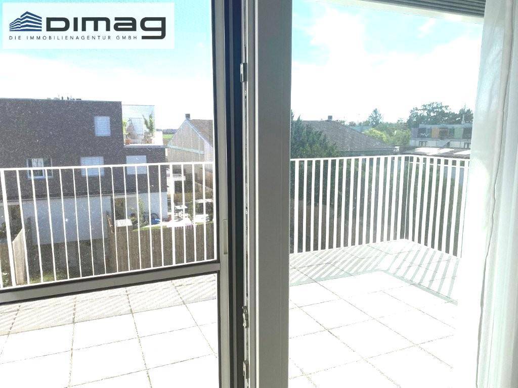 Geräumige Dachterrasse mit Fliesenboden und Blick auf die Umgebung.