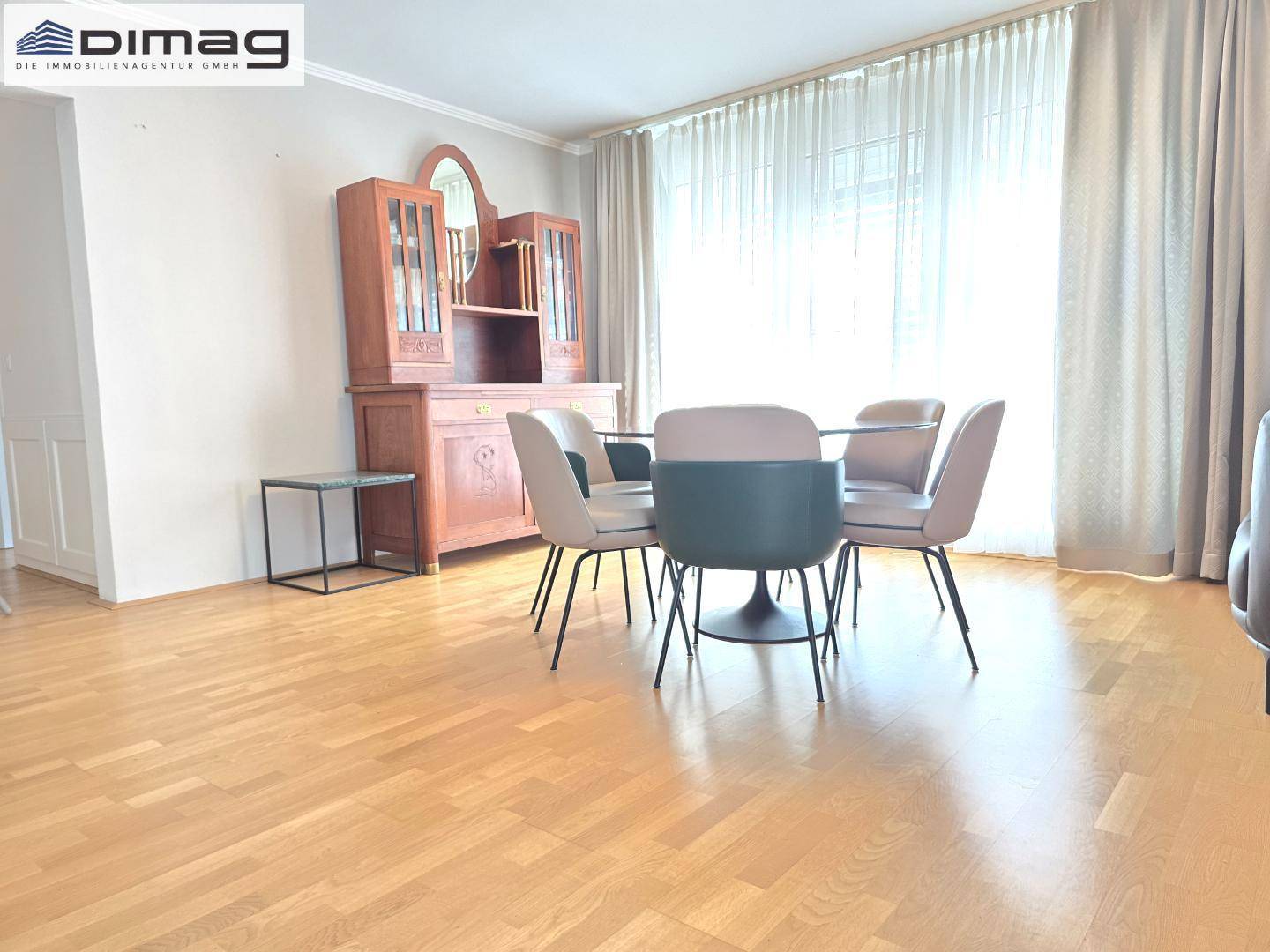 Gemütlicher Essbereich mit Holzboden, modernem Tisch und traditionellem Holzschrank.