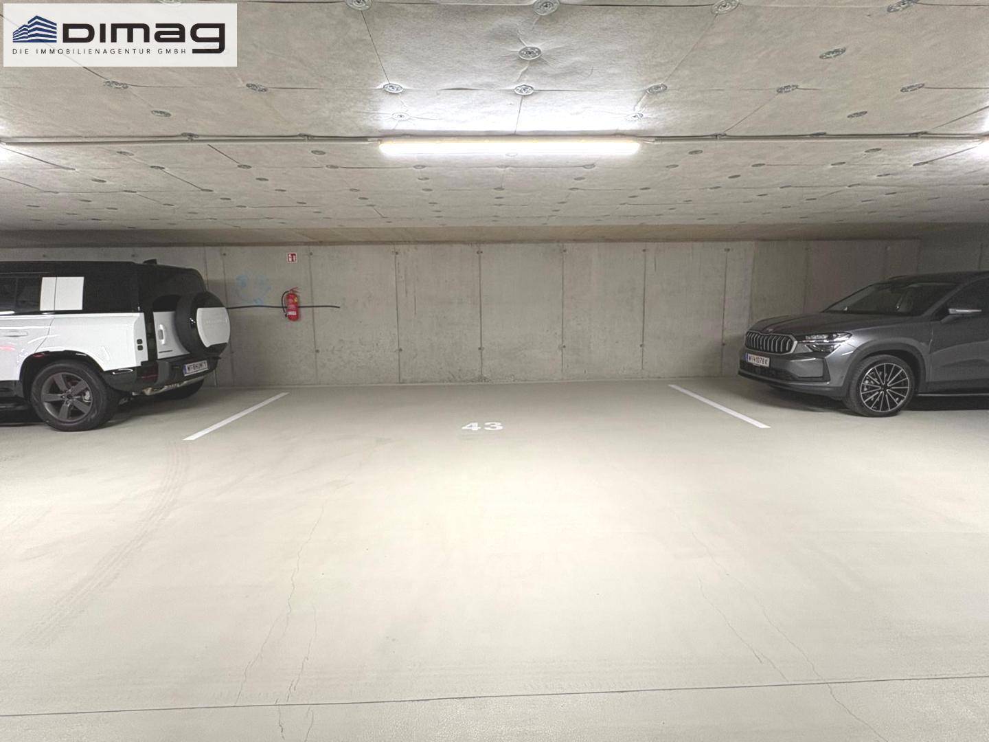Tiefgarage mit zwei Stellplätzen und Betonwänden, gut beleuchtet.