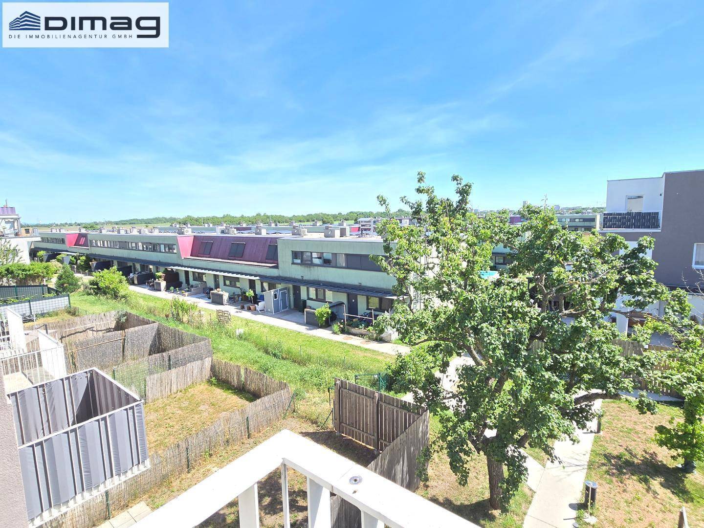 Weitläufiger Blick über die Wohnsiedlung und grüne Umgebung von der Dachterrasse.