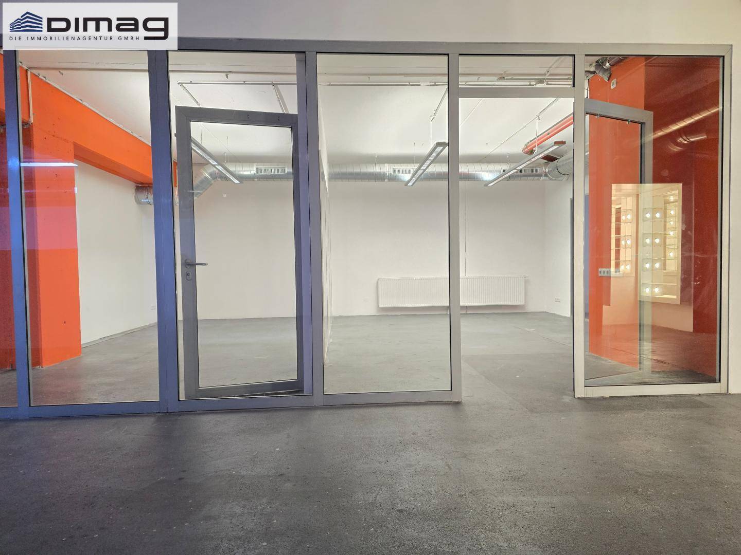 Gewerberaum mit modernen Glasabtrennungen und Türen, die verschiedene Bereiche voneinander trennen.