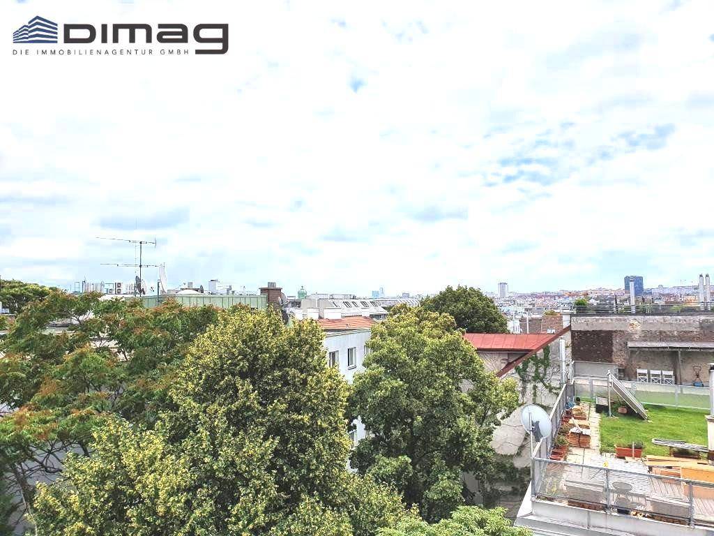 Panoramablick über die Stadt mit grünen Baumwipfeln und Gebäuden.