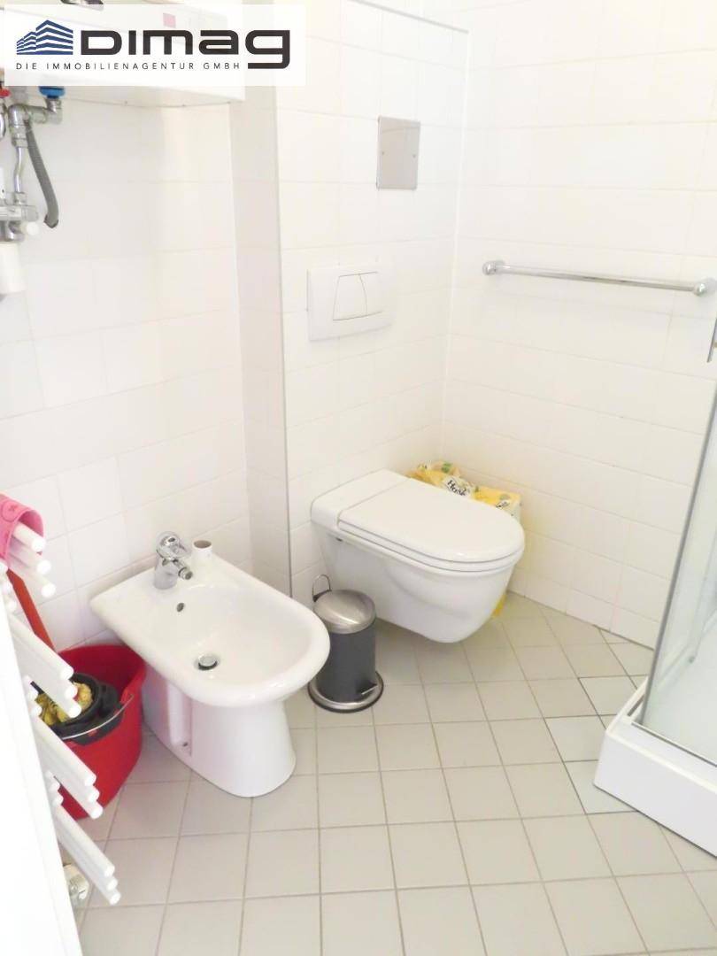 Badezimmer mit WC, Bidet und Duschkabine, ausgestattet mit hellen Fliesen.