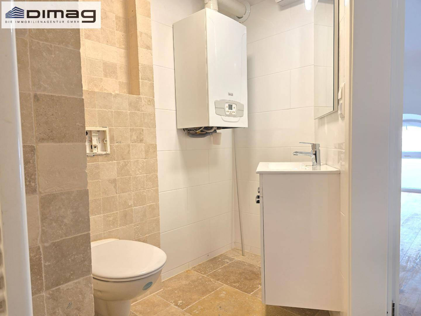 Kleines Badezimmer oder Gäste-WC mit WC, Waschbecken, Spiegelschrank und Wandheizung.