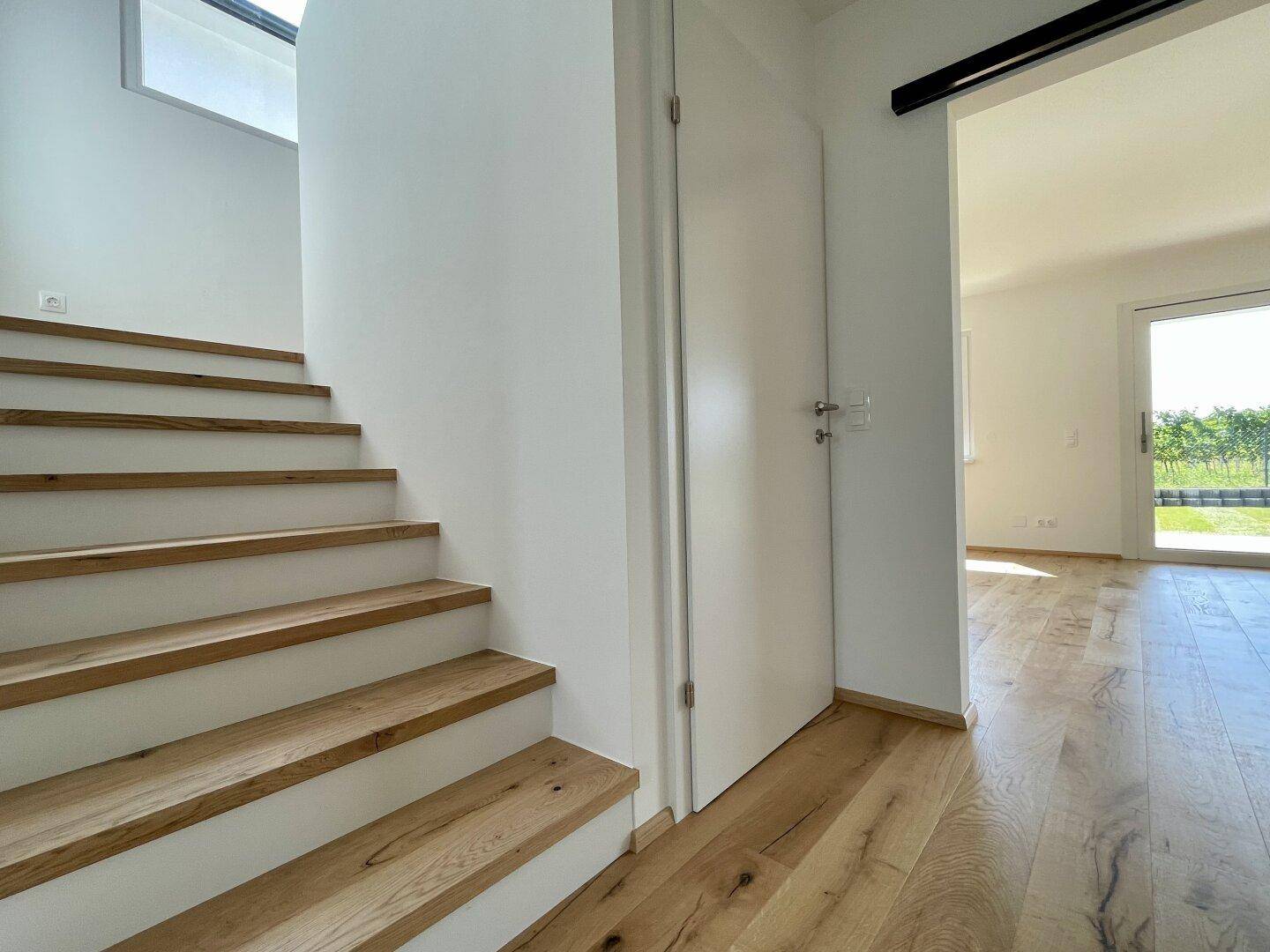Detailansicht der Holztreppe im hellen Flur, der zu den oberen Etagen des Hauses führt.