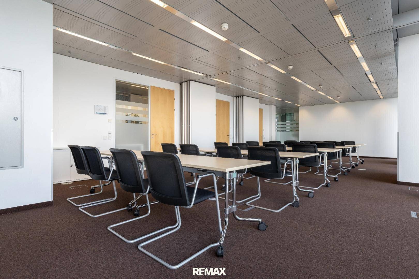Großer Schulungsraum mit flexiblen Tischen und Stühlen, ideal für Seminare und Workshops in einer professionellen Umgebung.
