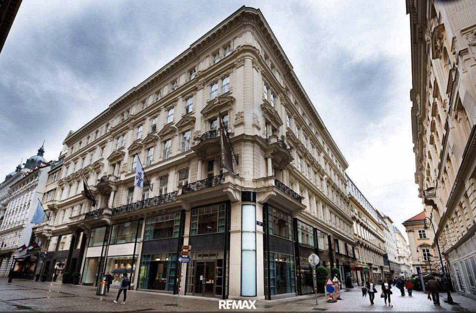 Prachtvolles Eckgebäude mit klassischer Architektur und großen Schaufenstern an einer belebten Stadtstraße.