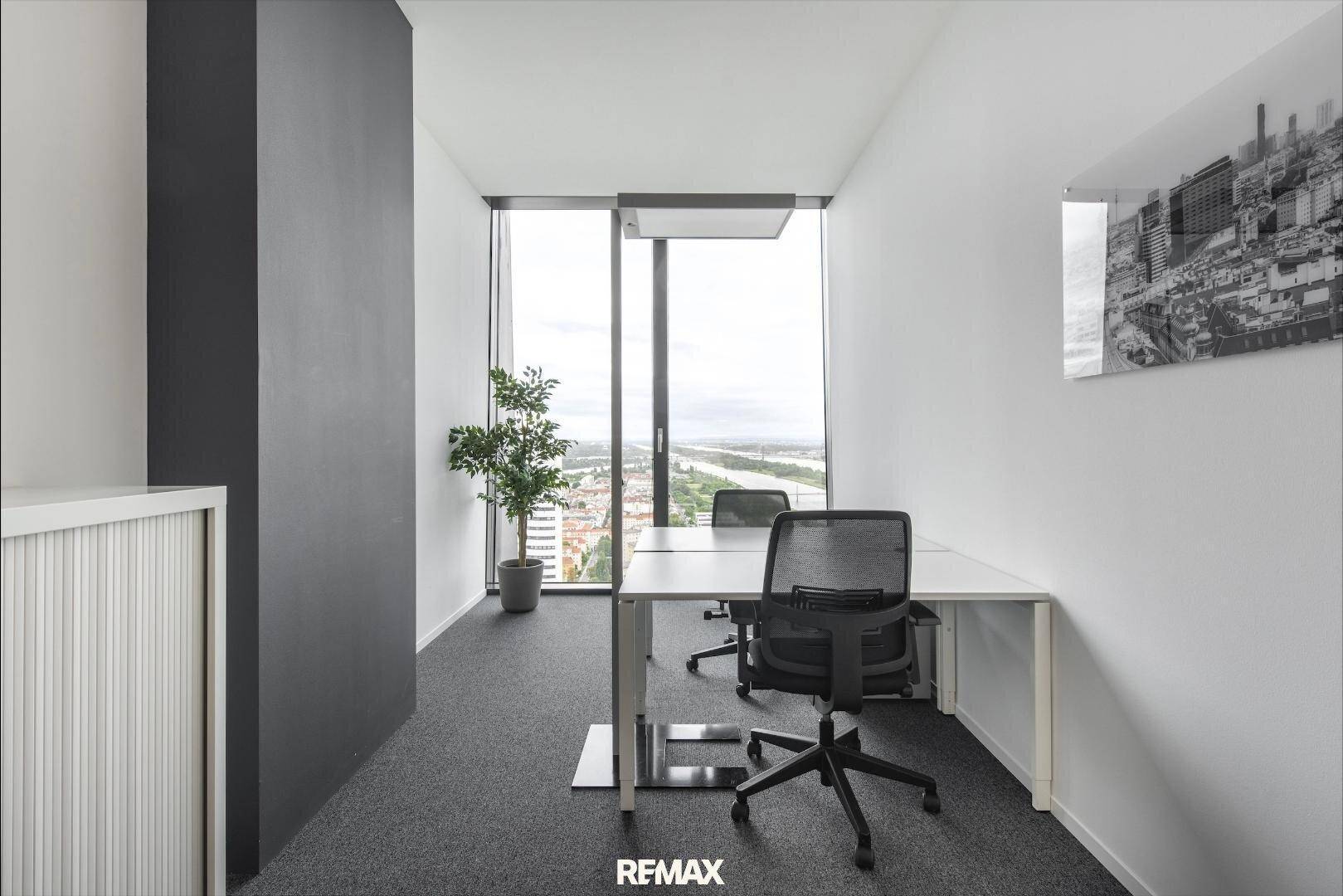 Helles Einzelbüro mit modernem Schreibtisch, Bürostühlen und großem Fenster mit Stadtblick.