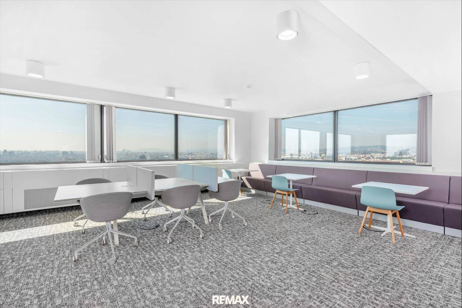 Geräumiges und lichtdurchflutetes Büro mit flexiblen Arbeitsbereichen, Sitzbänken und Panoramablick auf die Stadt.