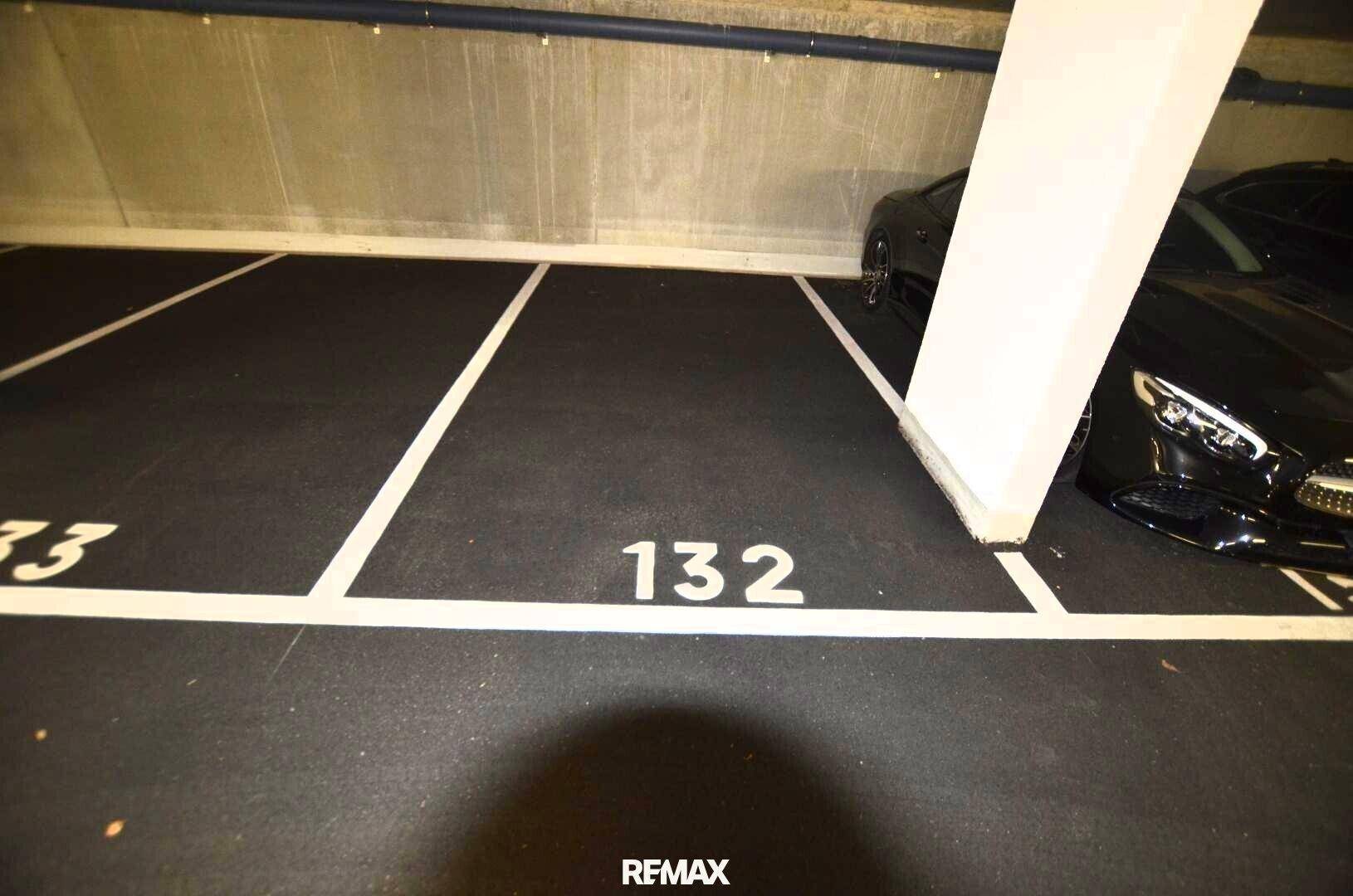 Einzelner Tiefgaragenstellplatz Nummer 132 neben einer tragenden Betonsäule.