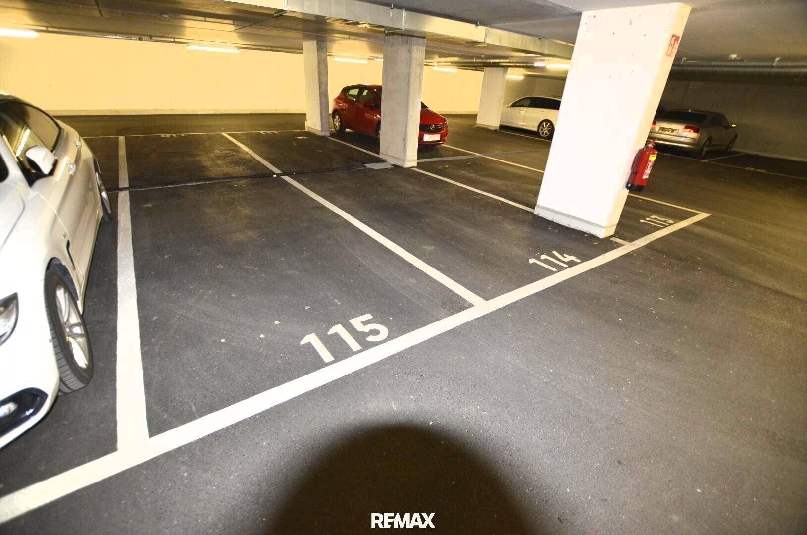 Geräumige Tiefgarage mit nummerierten Stellplätzen und mehreren geparkten Fahrzeugen.