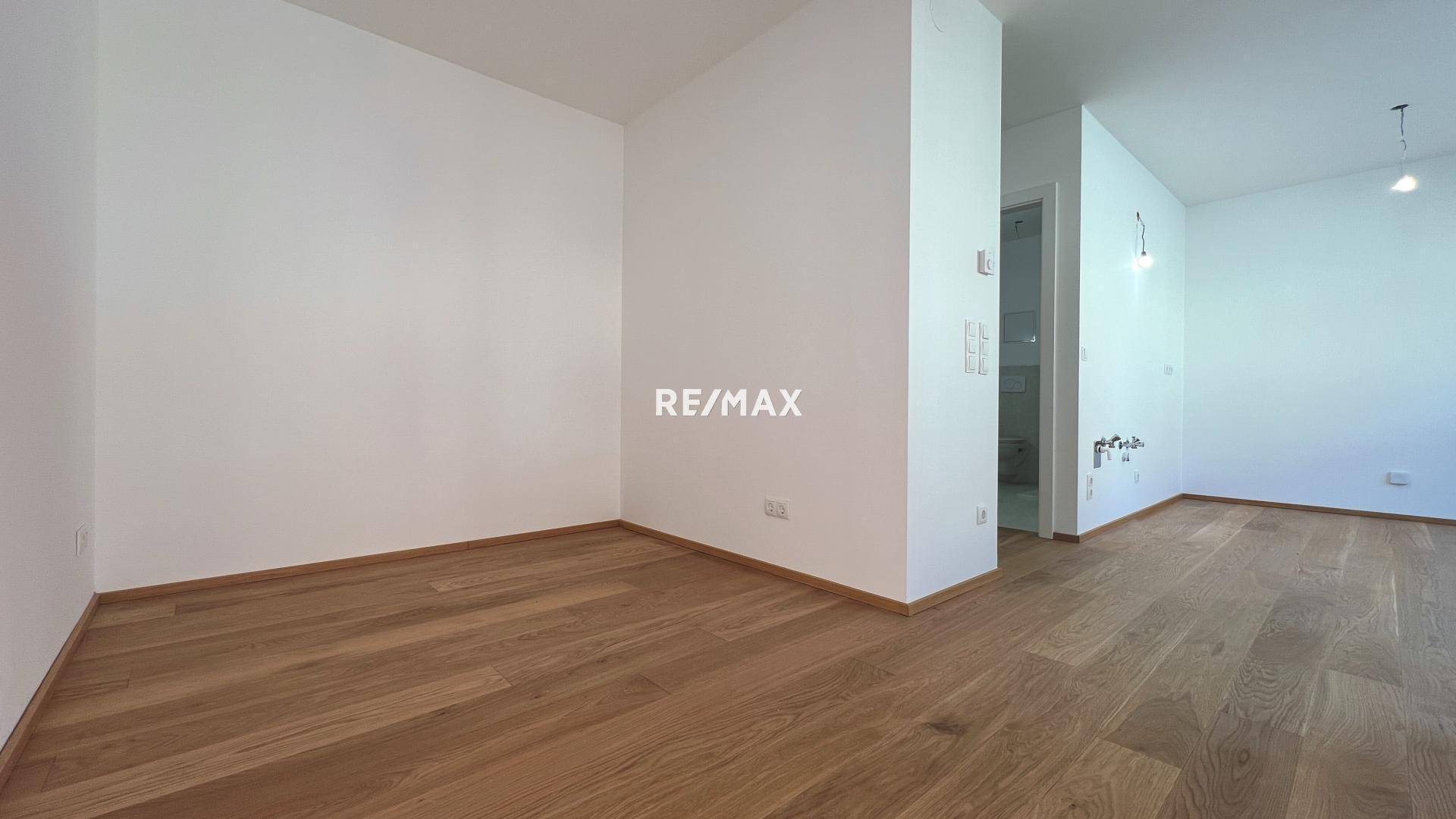 Heller, unmöblierter Wohnbereich mit Holzboden und weiß gestrichenen Wänden, ideal für neue Bewohner.