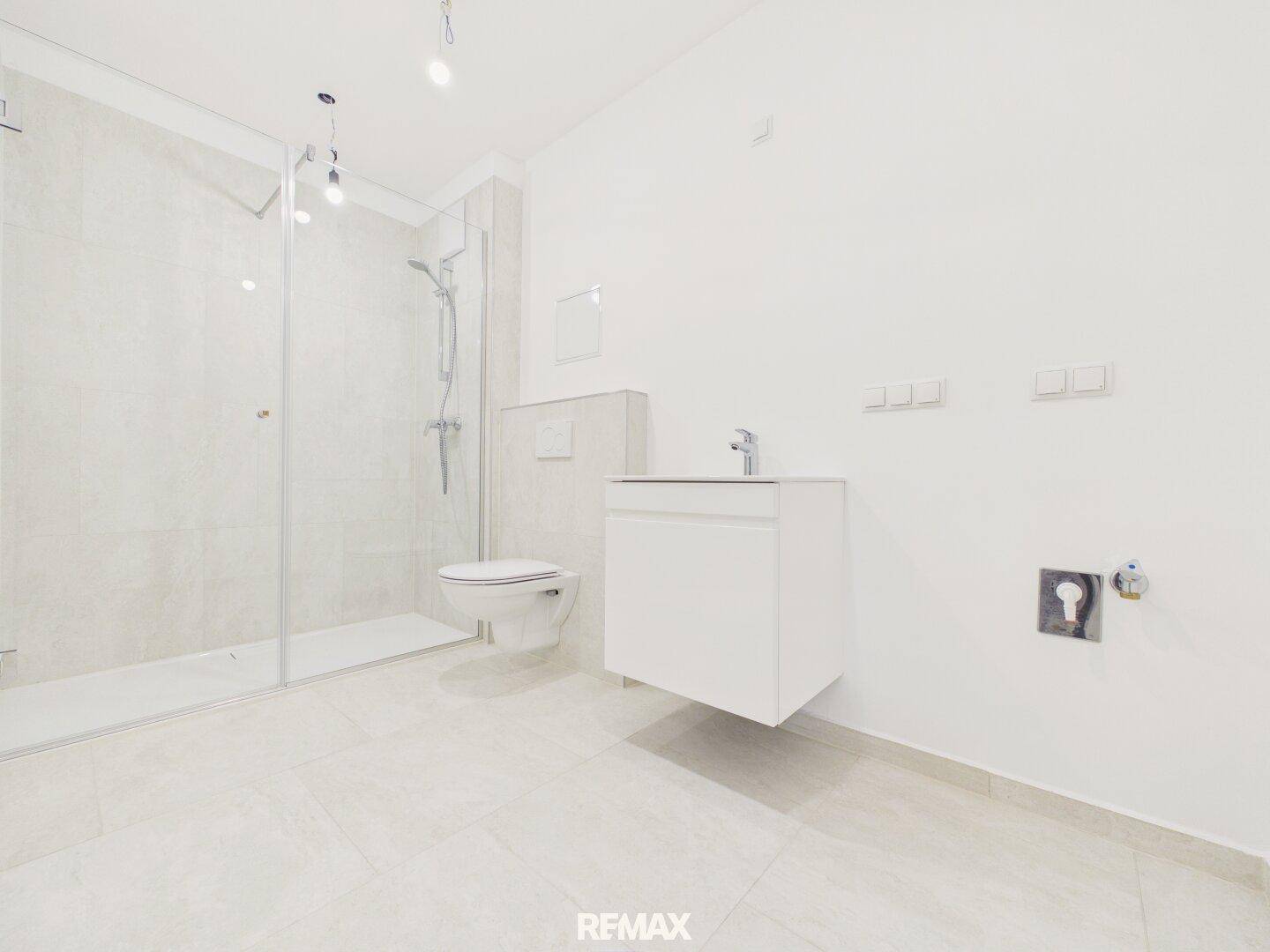 Modernes Badezimmer mit ebenerdiger Dusche, Hänge-WC und Waschtischunterschrank.
