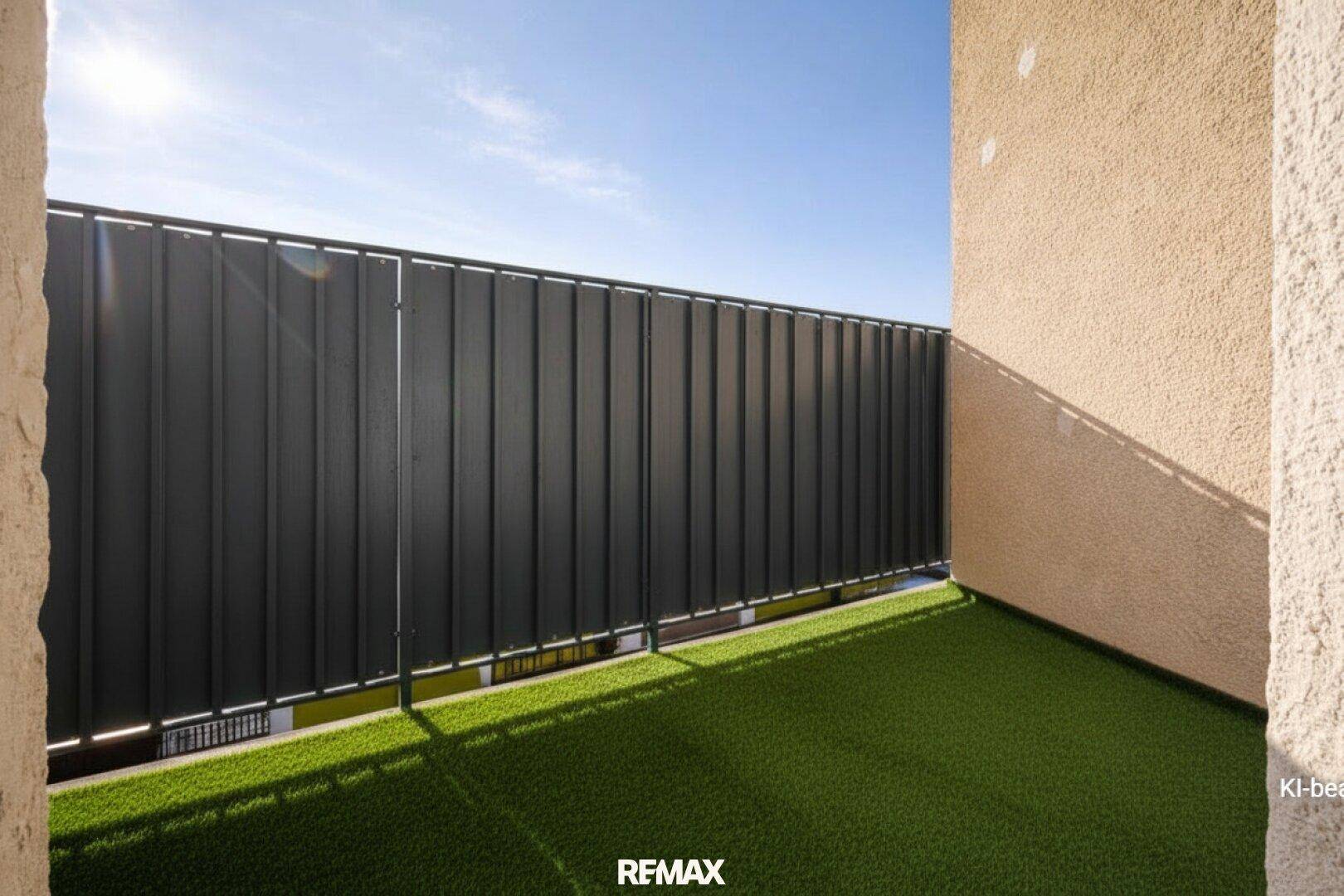 Sonniger Balkon mit Kunstrasen und Sichtschutz, ideal für entspannte Stunden im Freien.