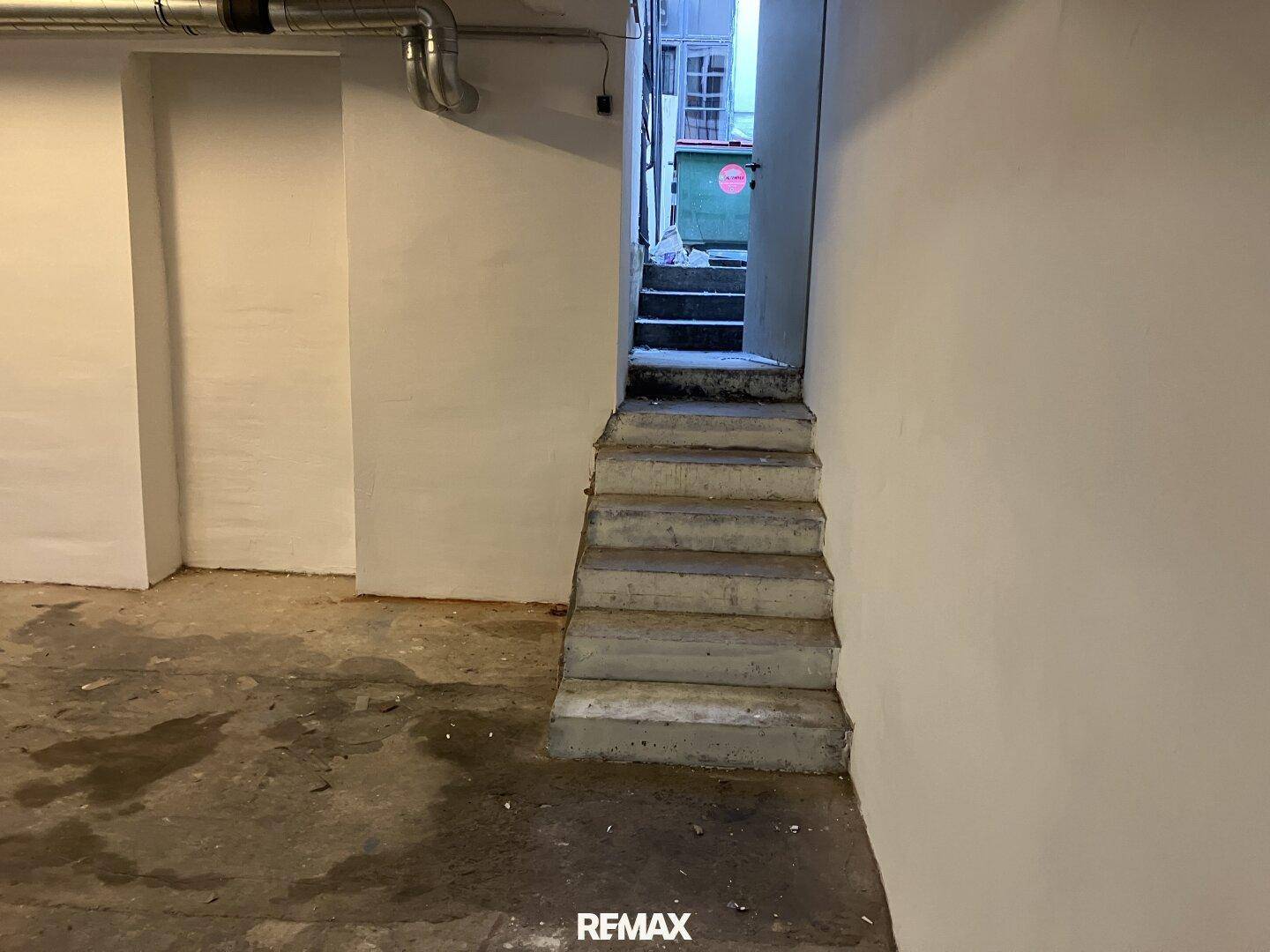 Betontreppe führt aus dem Untergeschoss nach oben zu einem Ausgangsbereich.
