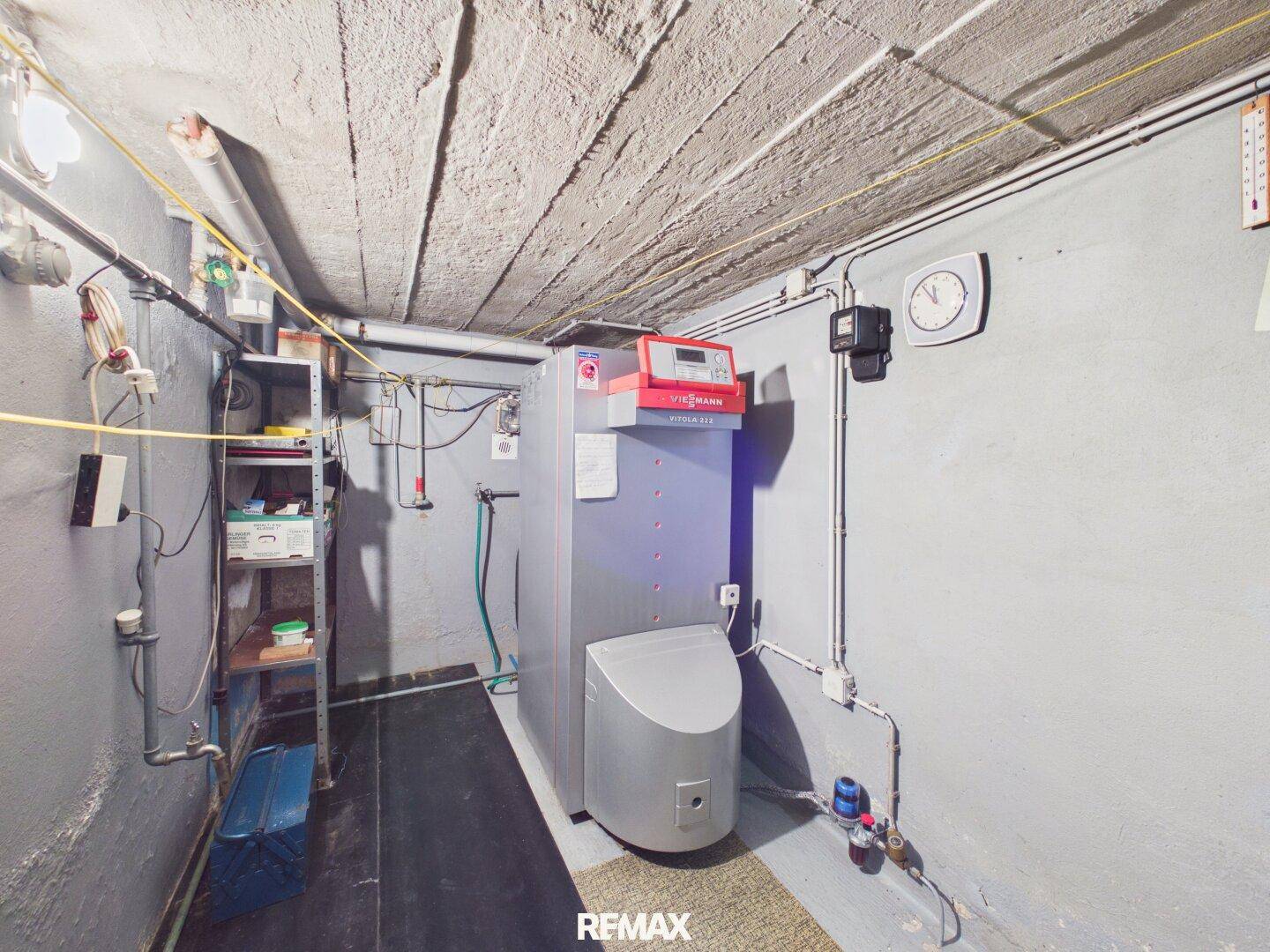 Technikraum im Keller mit Heizungsanlage und sichtbaren Installationen.