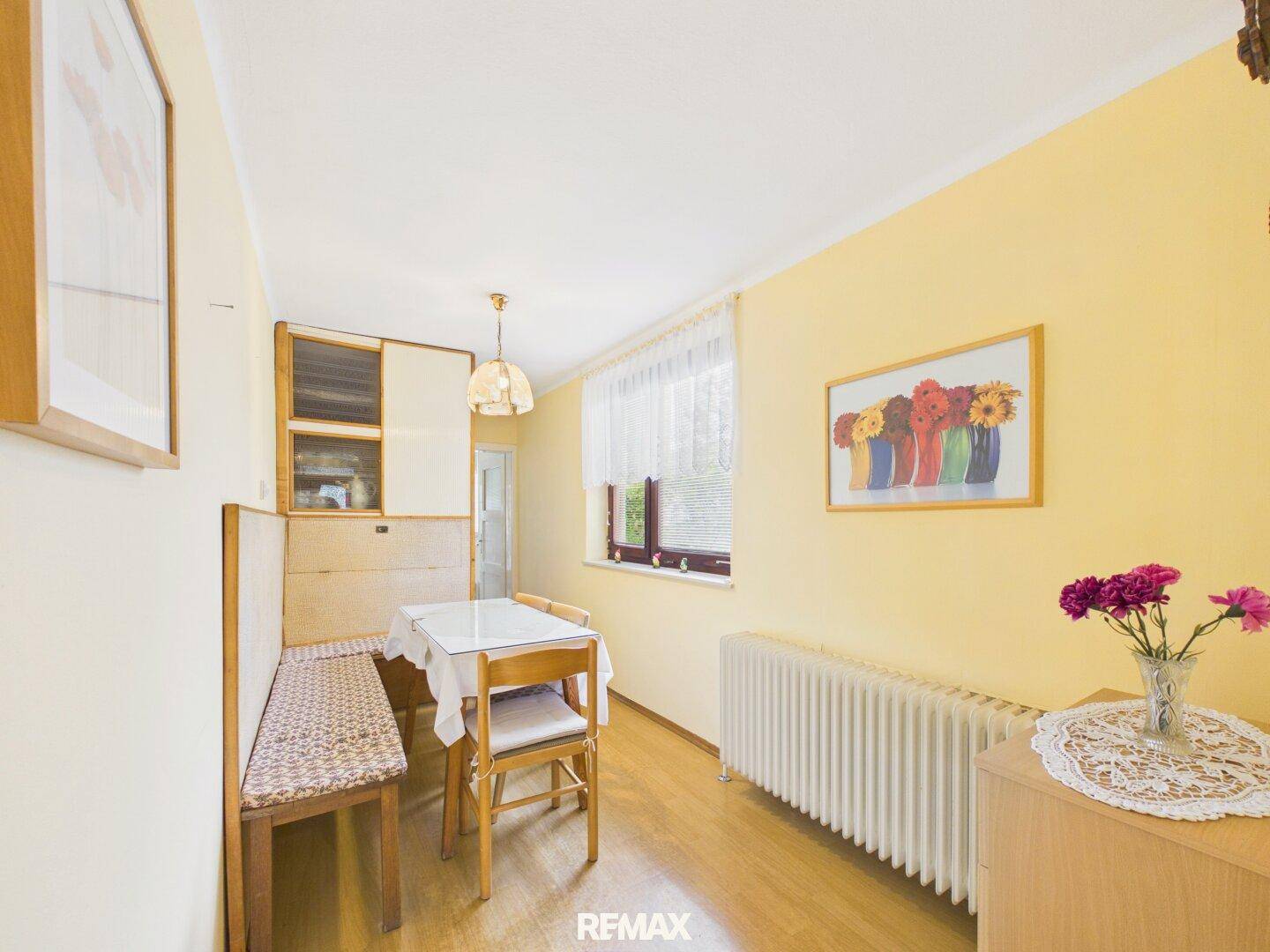 Heller Essbereich mit Holzbänken, Esstisch und gelben Wänden, ideal für Familienmahlzeiten.