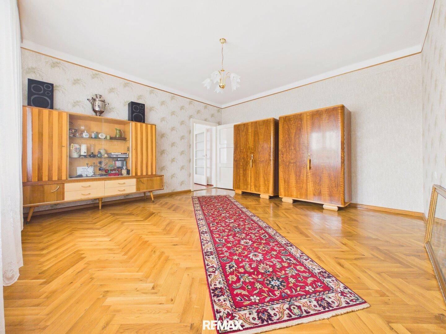Helles Schlafzimmer mit Holzparkett und klassischen Holzschränken.