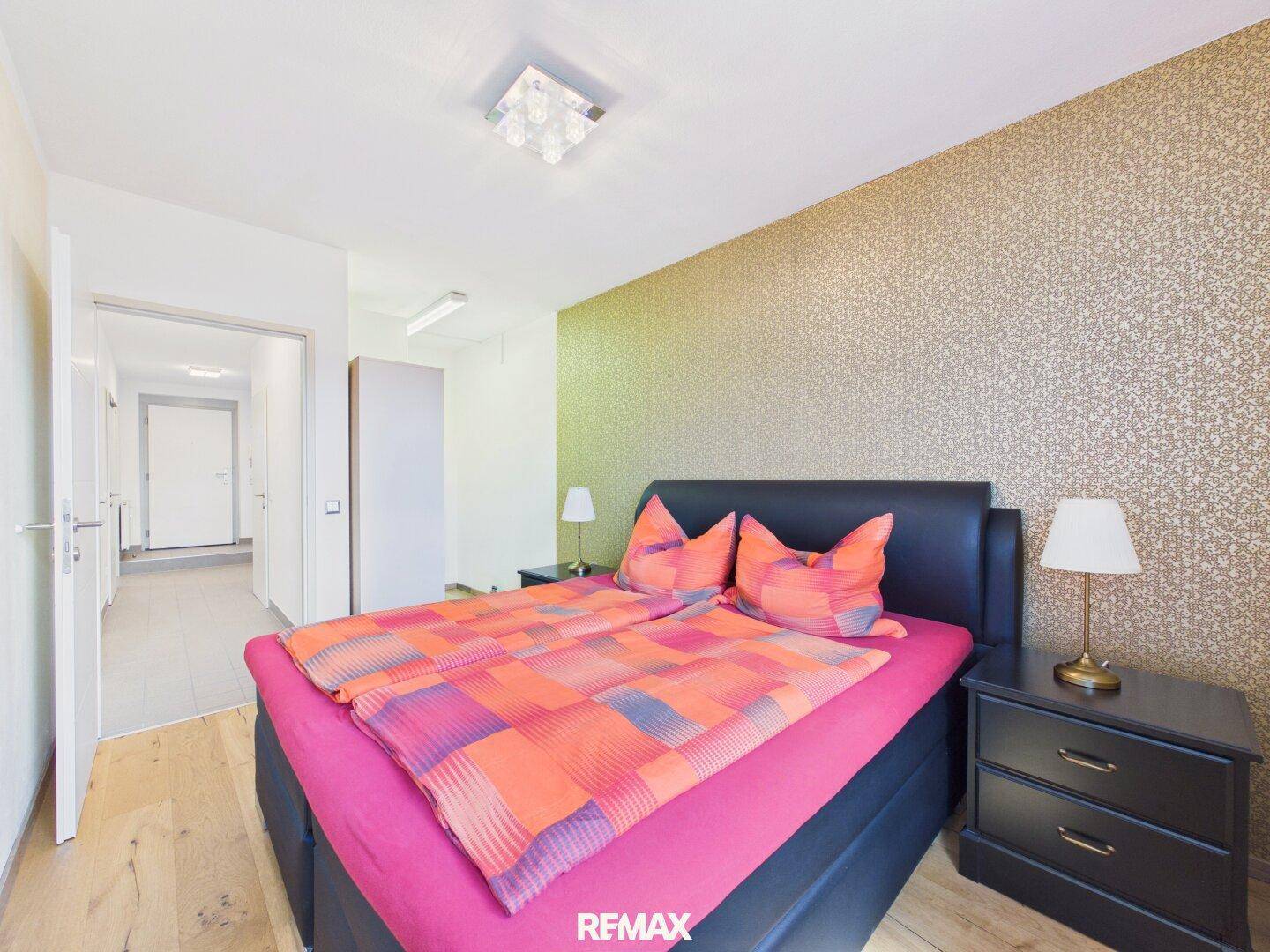 Gemütliches Schlafzimmer mit Doppelbett, Nachttischen und einer auffälligen strukturierten Akzentwand.