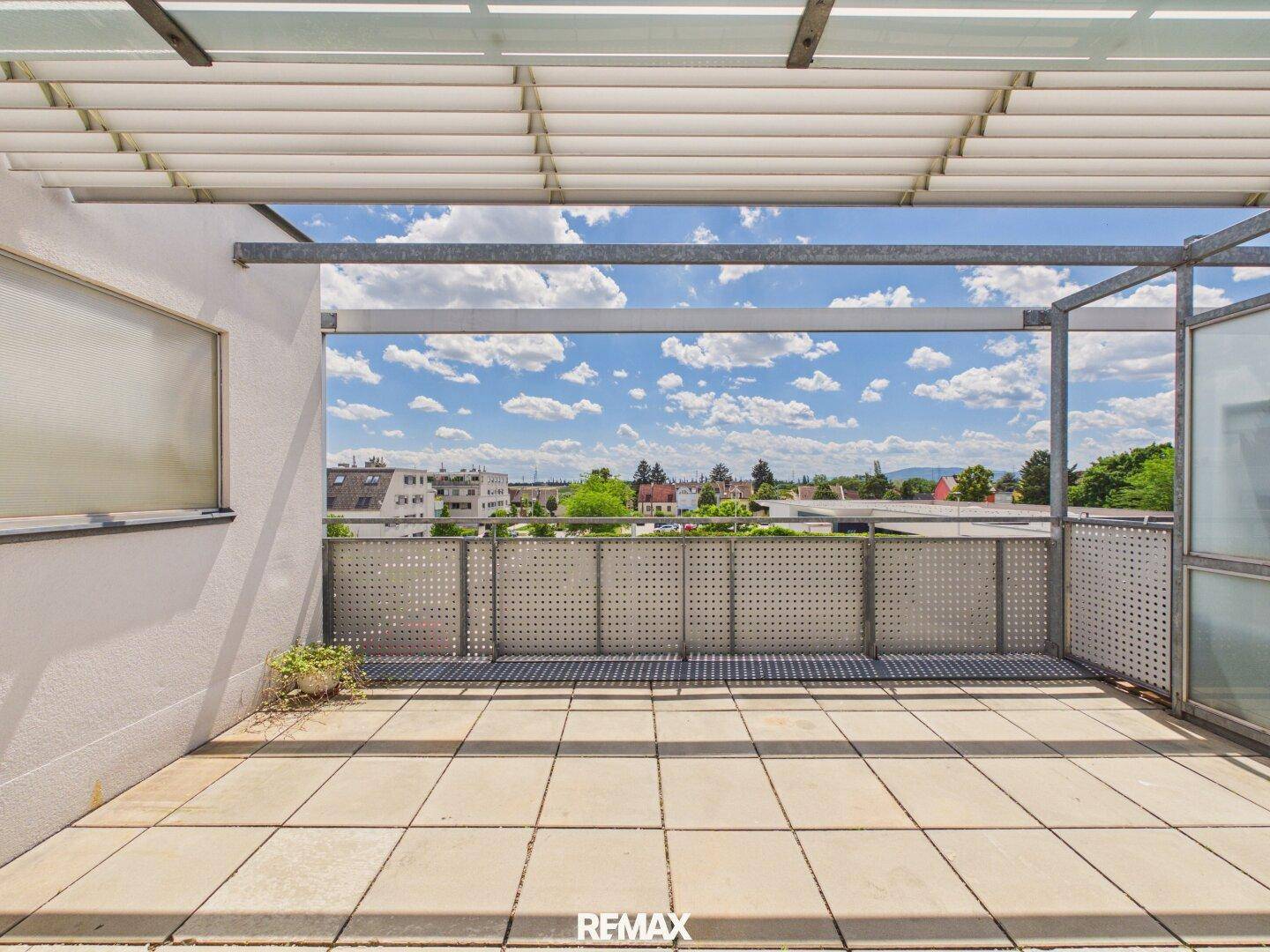 Geräumige Terrasse mit Fliesenboden und weitem Blick über die Stadt und die Umgebung.