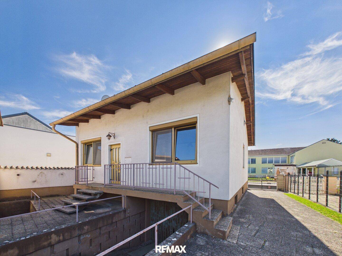 Seitenansicht des Hauses mit Außentreppe und Zugang zum Kellerbereich.