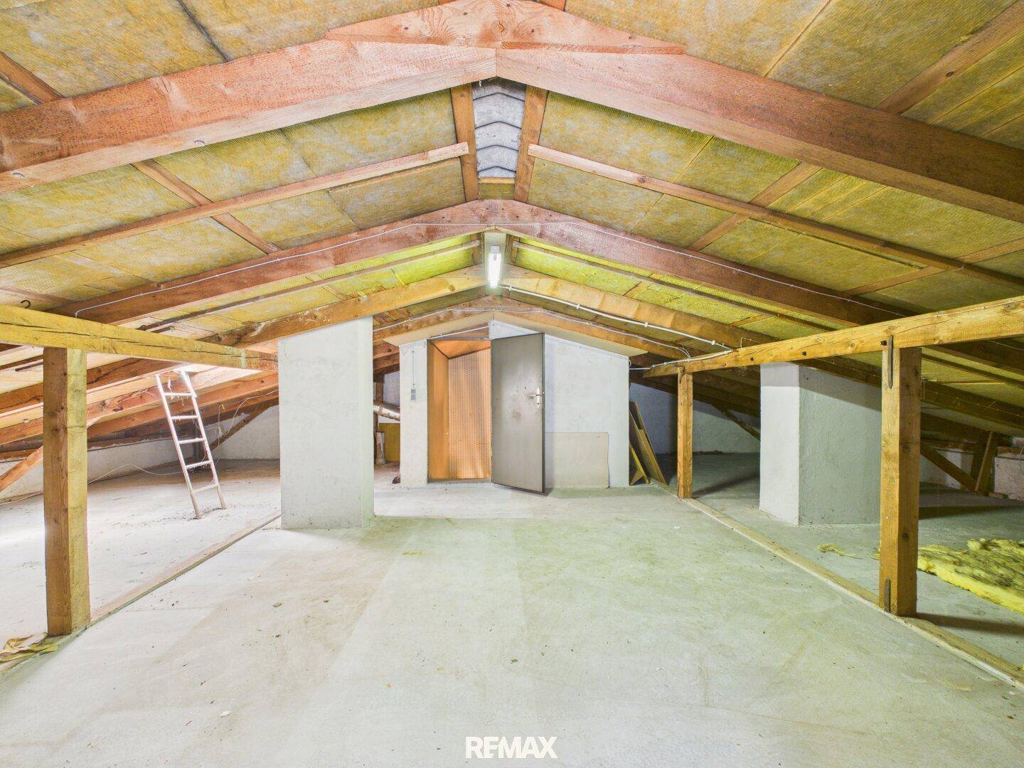 Dachboden mit sichtbaren Holzbalken und Isolierung, bietet Ausbaupotenzial.