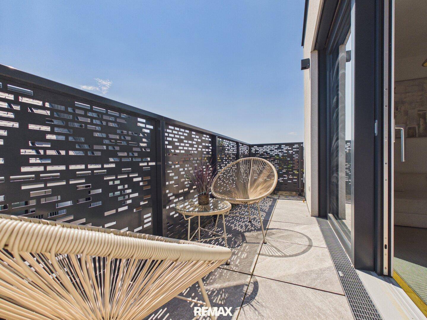 Geräumiger Balkon mit Sitzgelegenheiten und modernem Design, bietet einen angenehmen Außenbereich.