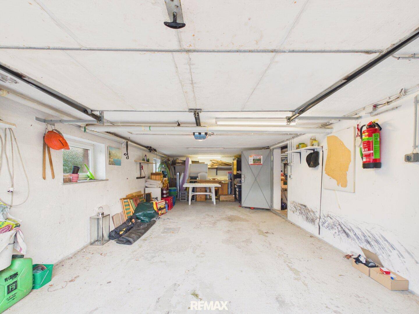 Geräumige Garage mit Stauraum und Fenster, ideal für Fahrzeuge und Werkstatt.