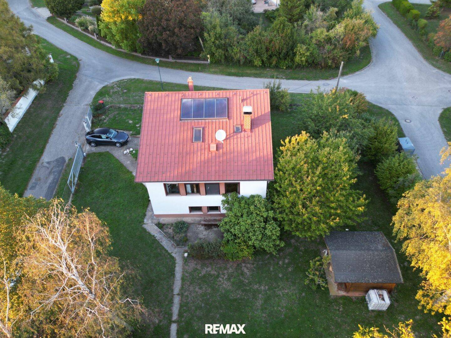 Luftaufnahme des Hauses mit rotem Dach, Solarpaneelen und großem Gartenbereich.