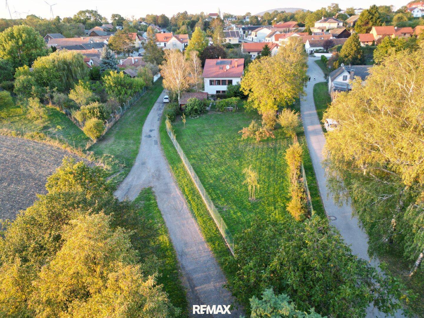 Weitläufige Luftaufnahme eines Wohnhauses mit Garten und angrenzenden Feldern in ländlicher Lage.